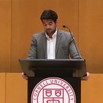 Man in a suitcoat at a Cornell podium