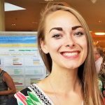 Woman with blond hair standing in front of research poster