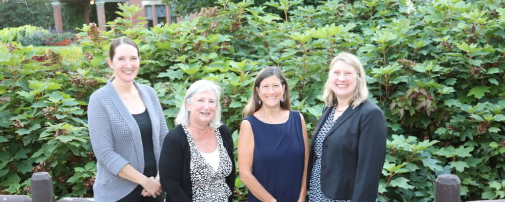 Four women in business dress outside the A.D. White House garden