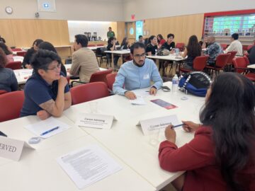 Two career staff talking with a student at a roundtable event